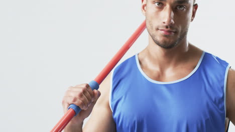 Young-biracial-athlete-man-holds-a-javelin-on-a-white-background