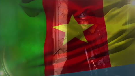 Animation-of-flag-of-cameroon-over-caucasian-male-soldier-holding-weapon-and-hiding