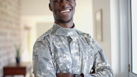 Glücklicher-Afroamerikanischer-Soldat,-Der-Im-Sonnigen-Wohnzimmer-Steht-Und-Lächelt,-Zeitlupe