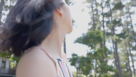 Happy-asian-woman-turning-around-and-smiling-in-sunny-garden,-slow-motion