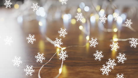 Animation-of-snow-falling-over-christmas-fairy-lights