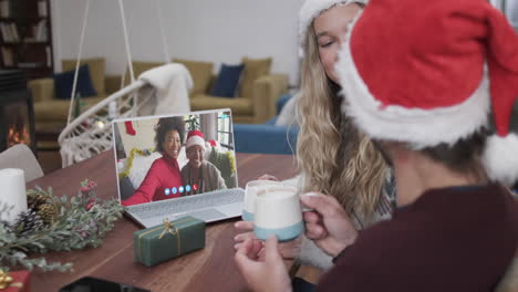 Happy-diverse-couple-and-mother-with-daughter-having-christmas-laptop-video-call,-slow-motion