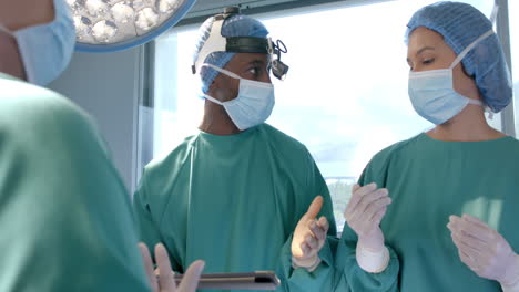 Diverse-female-and-male-surgeons-in-masks-in-discussion-during-operation,-slow-motion