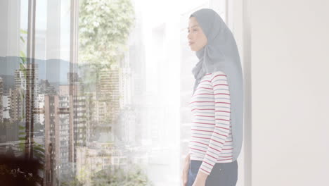 Animation-of-cityscape-over-biracial-woman-in-hijab-thinking