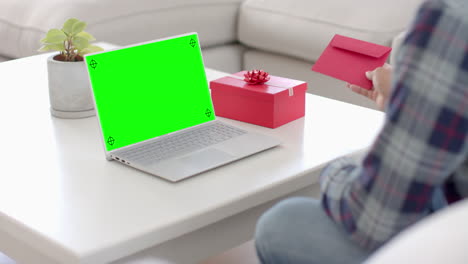 Kaukasischer-Mann-Hält-Umschlag-Und-Benutzt-Laptop-Mit-Kopierplatz-Auf-Grünem-Bildschirm