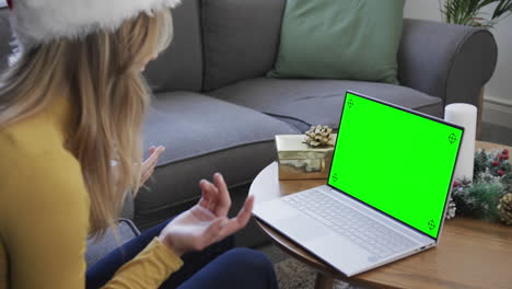 Happy-caucasian-woman-having-christmas-laptop-video-call-with-green-screen,-slow-motion