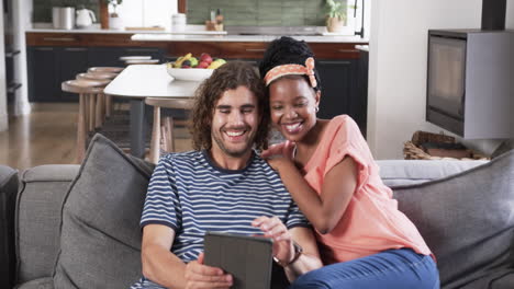 Diverse-couple-enjoys-a-tablet-in-a-cozy-home-setting
