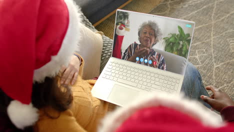 Glückliches,-Vielfältiges-Paar-Und-ältere-Mutter-Mit-Weihnachtlichem-Laptop-Videoanruf,-Zeitlupe