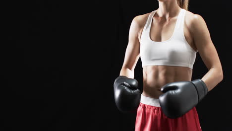 Junge-Kaukasische-Boxerin-In-Boxausrüstung-Posiert-Selbstbewusst-Auf-Schwarzem-Hintergrund