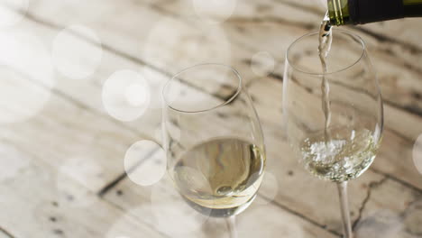 Komposit-Aus-Weißwein,-Der-In-Gläser-Auf-Holzoberfläche-Gegossen-Wird