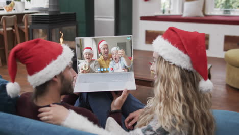 Glückliches-Kaukasisches-Paar-Und-Vater-Mit-Söhnen,-Die-Einen-Weihnachtlichen-Laptop-Videoanruf-In-Zeitlupe-Führen