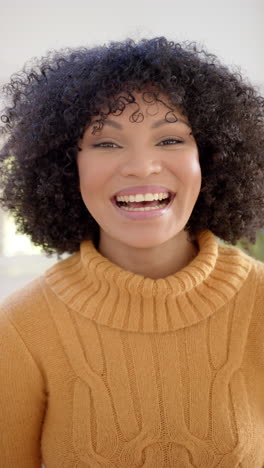 Vertical-video-of-portrait-of-happy-african-american-woman-at-home,-slow-motion
