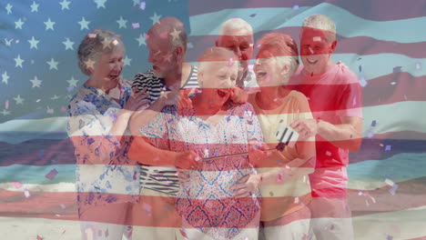 Animation-of-flag-of-usa-over-caucasian-senior-friends-on-beach-in-summer