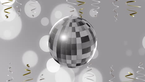 Animation-of-party-streamers-and-mirror-disco-ball-on-grey-background