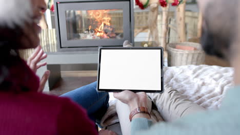 Happy-diverse-couple-having-christmas-tablet-video-call-with-copy-space-screen,-slow-motion