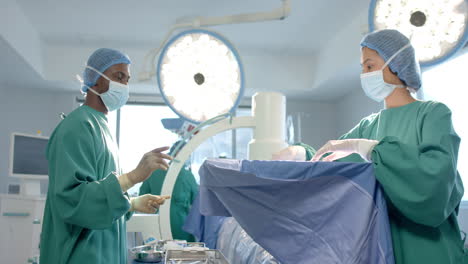 Verschiedene-Chirurginnen-Und-Chirurgen-Mit-Masken-Unterhalten-Sich-Im-Operationssaal,-Zeitlupe