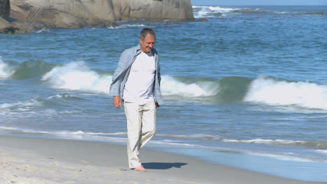 Elderly-man-walking-along-the-beach