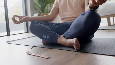 Senior-biracial-man-practicing-yoga-meditation-at-home