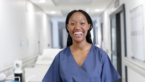 Retrato-De-Una-Feliz-Doctora-Afroamericana-Usando-Batas-En-El-Hospital,-Cámara-Lenta