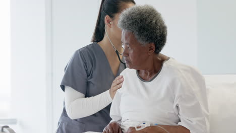 Doctora-Diversa-Examinando-A-Una-Paciente-Anciana-Usando-Estetoscopio-En-La-Habitación-Del-Hospital,-Cámara-Lenta