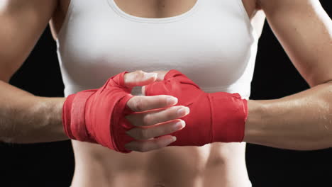 Young-Caucasian-woman-boxer-ready-for-a-boxing-workout-on-a-black-background
