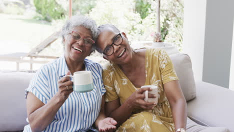 Porträt-Glücklicher-älterer-Afroamerikanischer-Freundinnen-Beim-Kaffeetrinken-Im-Wohnzimmer,-Zeitlupe