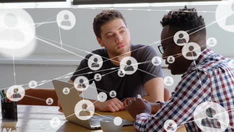 Animation-of-network-of-connections-with-icons-over-diverse-businessmen-discussing-work
