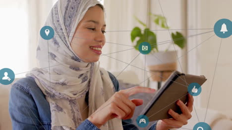 Animation-of-connections-with-icons-over-biracial-woman-in-hijab-using-tablet