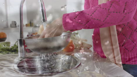 Biracial-woman-washing-vegetables-in-kitchen,-cooking-over-water-drops