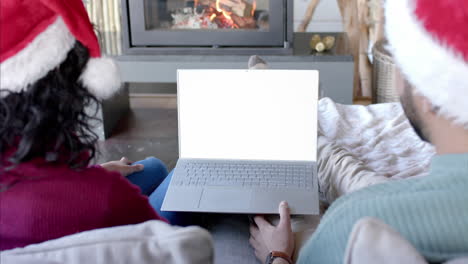 Glückliches,-Abwechslungsreiches-Paar-Mit-Weihnachtlichem-Laptop-Videoanruf-Mit-Kopierbildschirm,-Zeitlupe