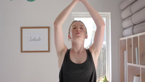 Fokussierte-Kaukasische-Fitness-Frau-Praktiziert-Yoga-Im-Weißen-Raum,-Zeitlupe