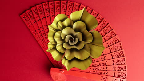 Animation-of-chinese-pattern-and-fan-with-copy-space-on-red-background