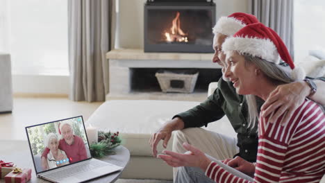 Happy-caucasian-couple-and-senior-parents-having-christmas-laptop-video-call,-slow-motion