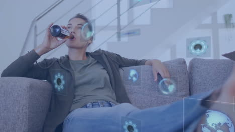 Animation-of-data-processing-over-caucasian-woman-sitting-on-sofa-drinkking-beer