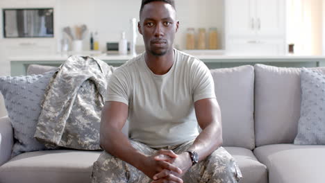 Young-African-American-soldier-sits-confidently-at-home,-with-copy-space