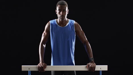 African-American-man-posing-with-hurdles-on-a-black-background