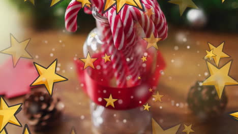 Animation-of-yellow-stars-over-jar-with-candy-canes-and-pinecones-on-wood-surface
