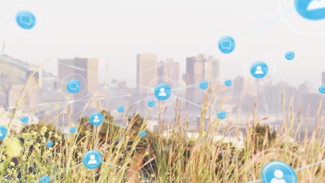 Animation-of-connected-icons-over-close-up-of-grass-against-modern-cityscape