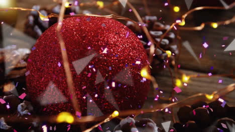 Animation-of-spots-of-light-over-christmas-red-bauble-and-fairy-lights-decorations