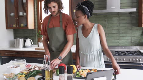 Young-African-American-woman-and-Caucasian-man-cooking-together-at-home
