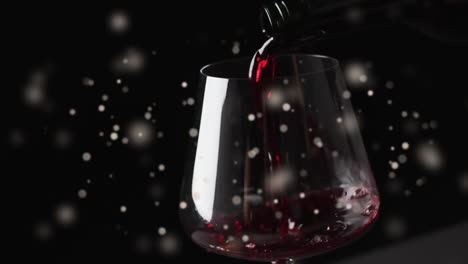 Composite-of-red-wine-being-poured-into-glass-over-black-background