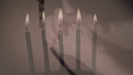 Animation-of-rosary-and-burning-candles-over-hands-parying