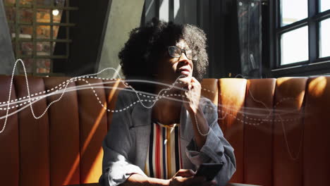Animation-of-connections-over-african-american-woman-in-cafe