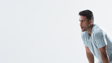 Young-biracial-man-athlete-focused-during-a-throwing-session-on-a-white-background,-with-copy-space