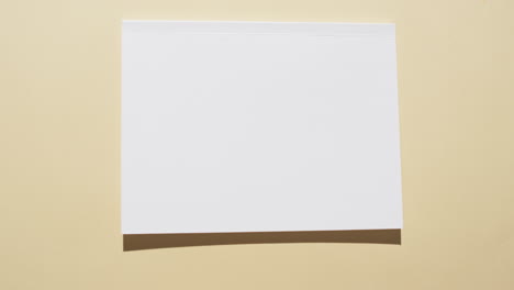 Video-of-book-with-blank-white-pages-and-copy-space-on-yellow-background