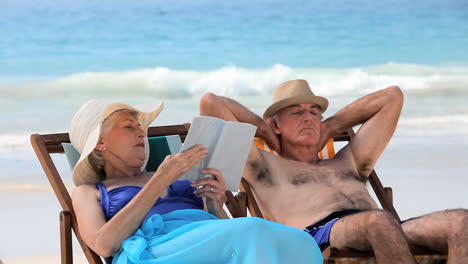 Aged-couple-relaxing-on-beach-chairs