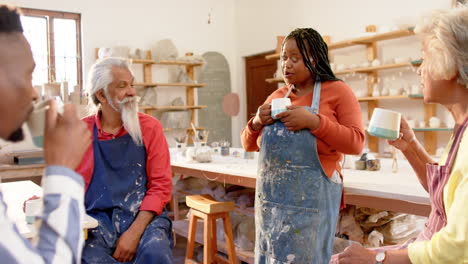 Happy-diverse-group-of-potters-having-break-and-discussing-in-pottery-studio