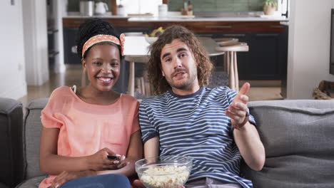 Diverse-couple-enjoys-a-relaxed-moment-at-home-watching-a-movie