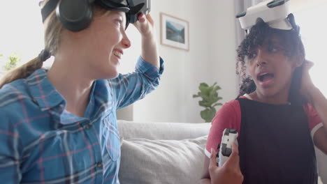 Fröhliche,-Vielfältige-Freundinnen-Im-Teenageralter,-Die-Zu-Hause-Videospiele-Mit-VR-Headsets-Spielen,-Zeitlupe