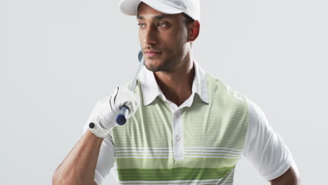 Young-biracial-man-dressed-in-golf-attire-poses-confidently